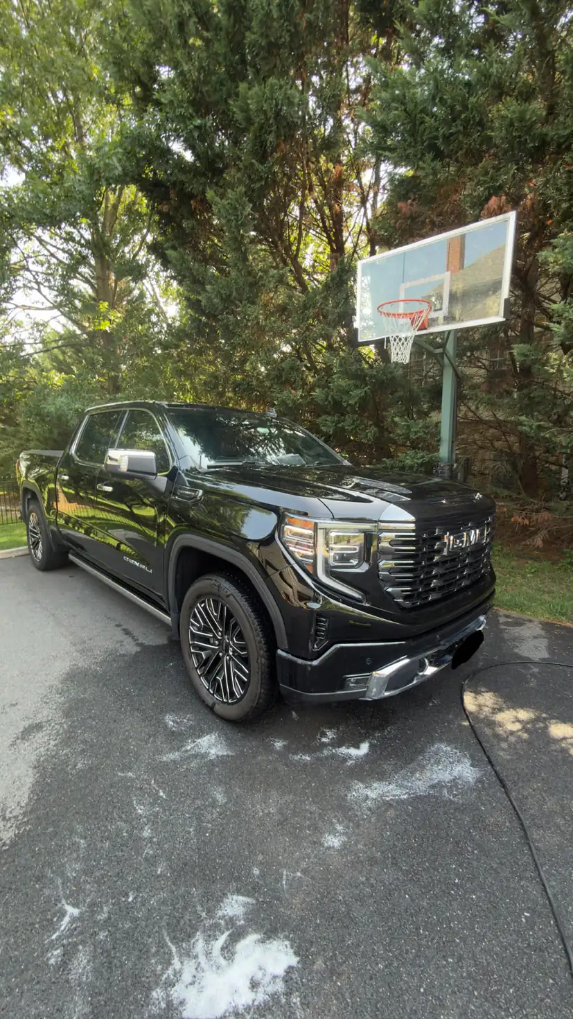 Freshly detailed black GMC Sierra Denali on a residential driveway